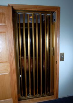 Home Elevator with accordion car gate - all smoked plexiglas and brass color trim