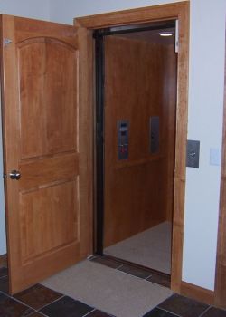Home Elevator with maple interior and carpeted floor