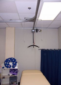 Ceiling track lift with lifter over exersize table